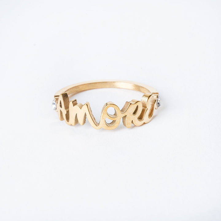 Gold plated amore ring , standing in the center of the image against a white background. 