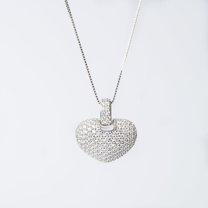 A silver necklace with a heart-shaped pendant featuring cubic zirconia stones.