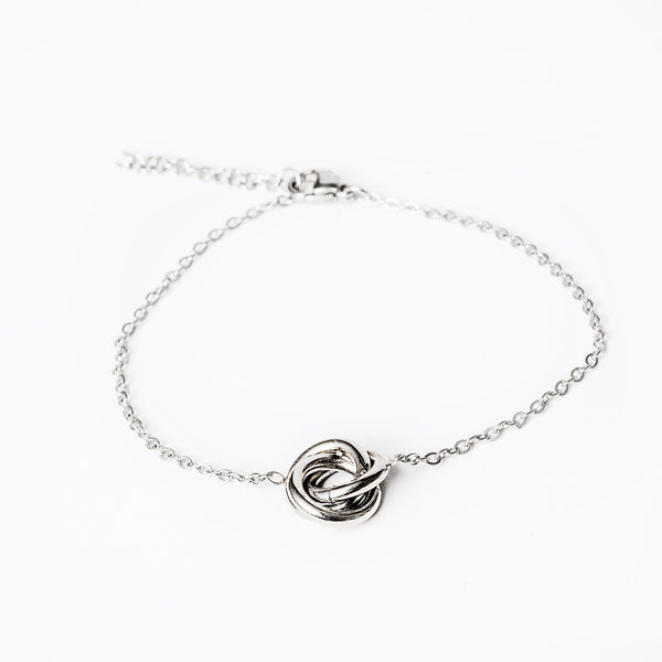 a silver bracelet standing in the center of the image against a white background. 