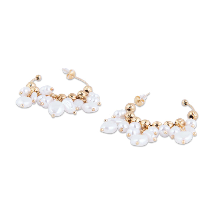 Pair of gold and pearl earrings close up look 