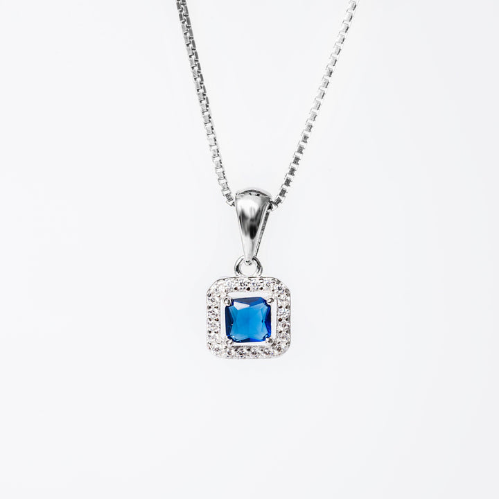 An Edith necklace blue stone close up against a white background 