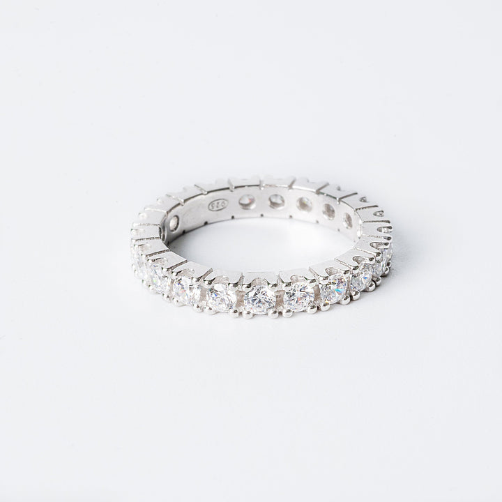 Fiona ring with multiple inset stones set around its circumference, standing against a white background. 