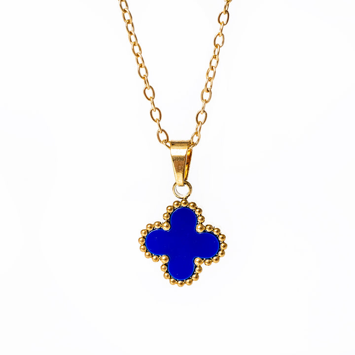 A close up view of Fiore necklace with blue pendant standing in the center of the image against a white background 