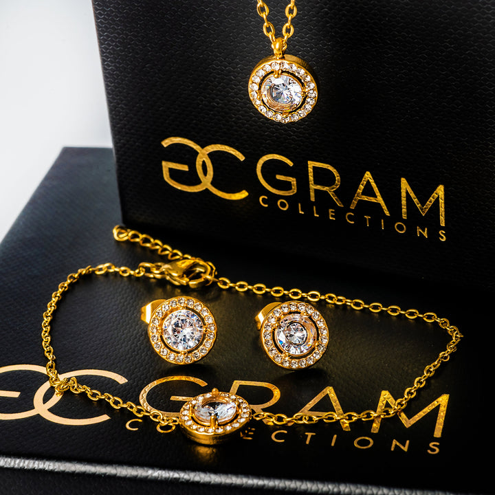 Gabby Gold Necklace standing in the center of the image placed on its uniquely designed box. 