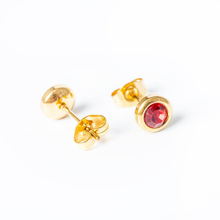 A close up view of Gabriella Gold Earrings with red pendant 