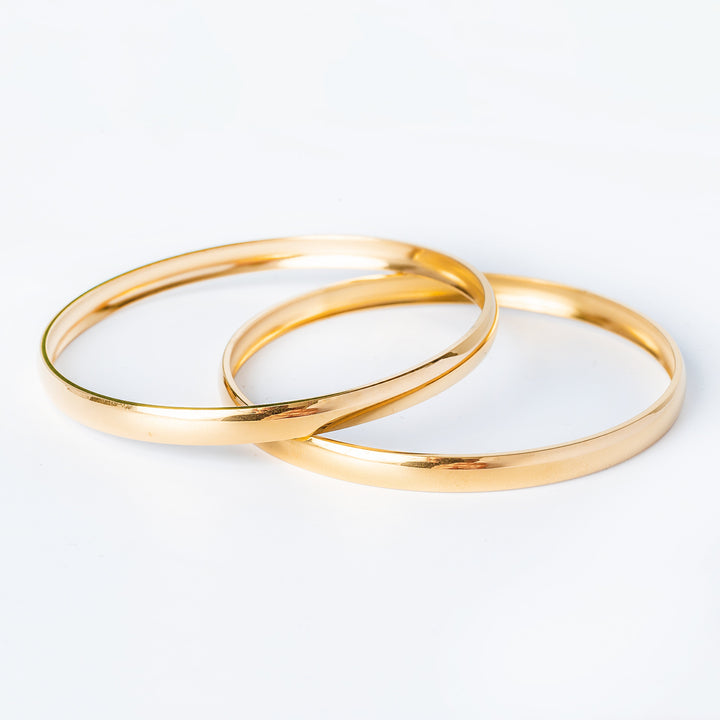 Kolina Fili gold plated bracelets standing against a white background. 