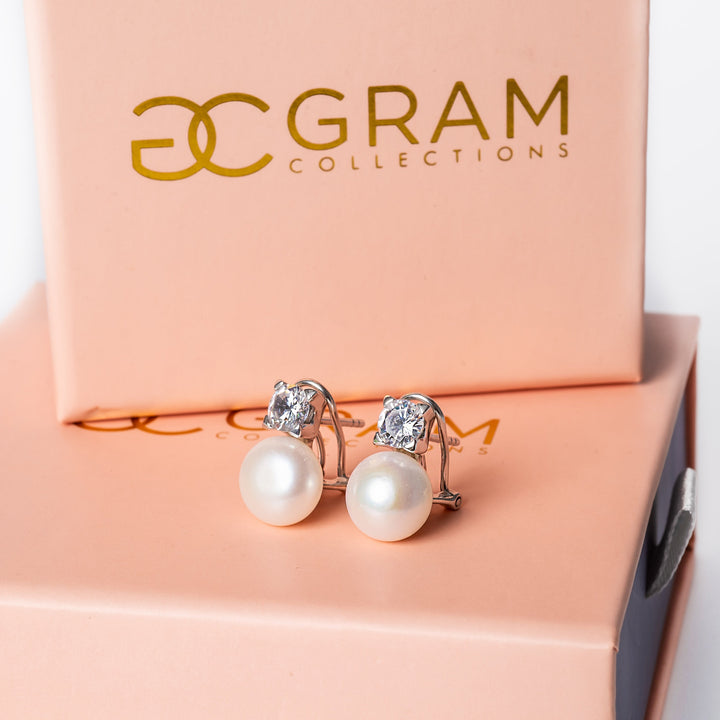 gram collections earrings standing against a white background placed on their uniquely designed pink box. 