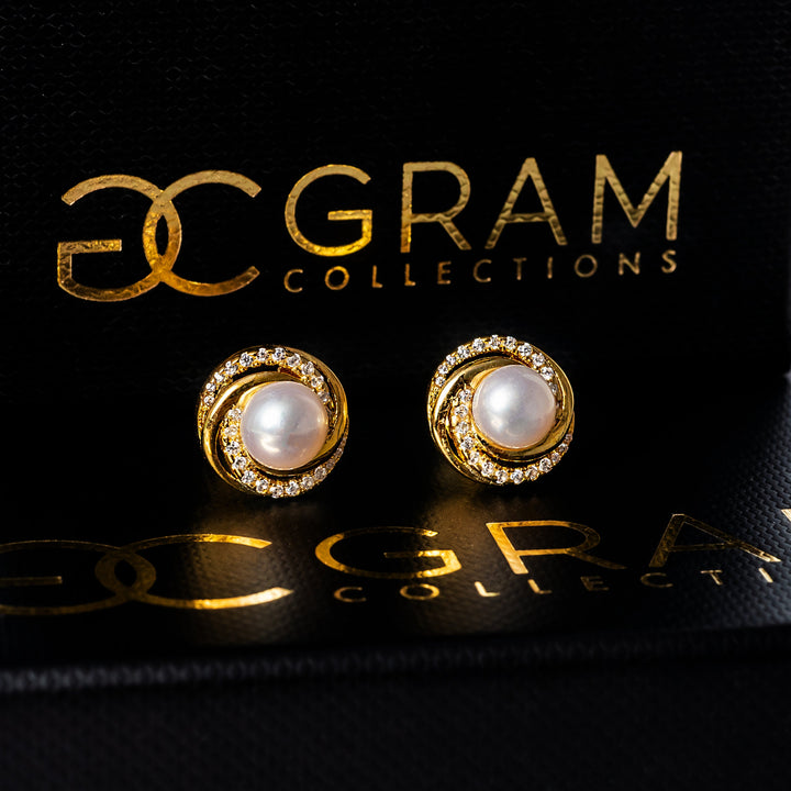 A close up view of Louanne pair of earrings placed on their uniquely designed box. 