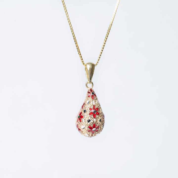 A sterling lucija necklace with a yellow gold chain and a teardrop-shaped pendant featuring red enamel.