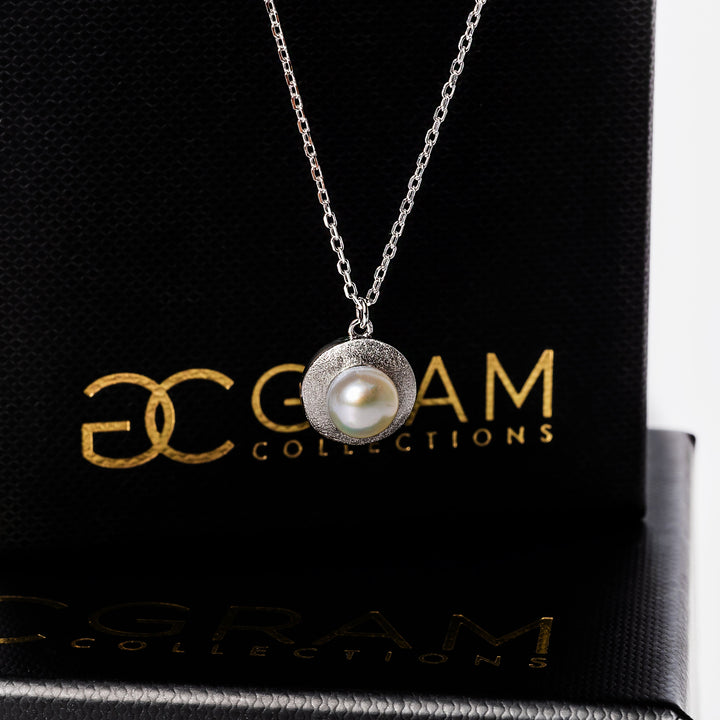 a gram collections Luidsy Necklace in front of its uniquely designed box. 