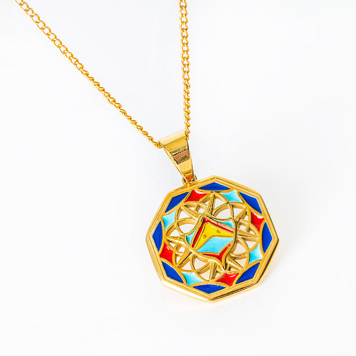 Gold necklace with a colorful geometric pendant on a white background