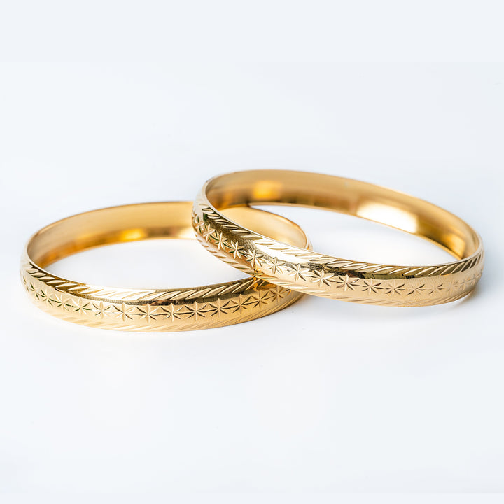 Maltese Fii pair of earrings standing on top of each other, in the center of the image. 