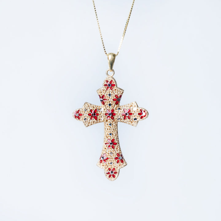 A sterling Marija necklace with a yellow gold cross pendant featuring red enamel accents, displayed against a white background.