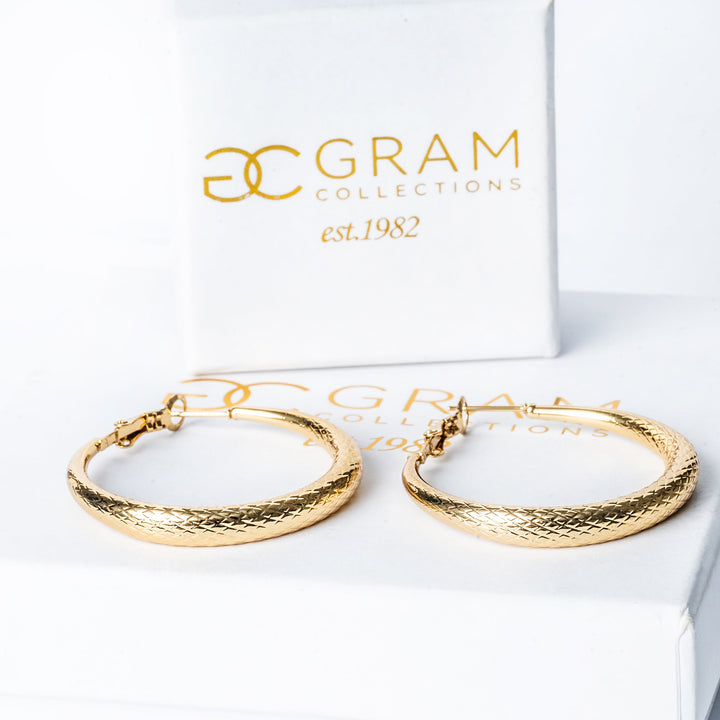 A gram earrings standing in the center of the image against a white background.