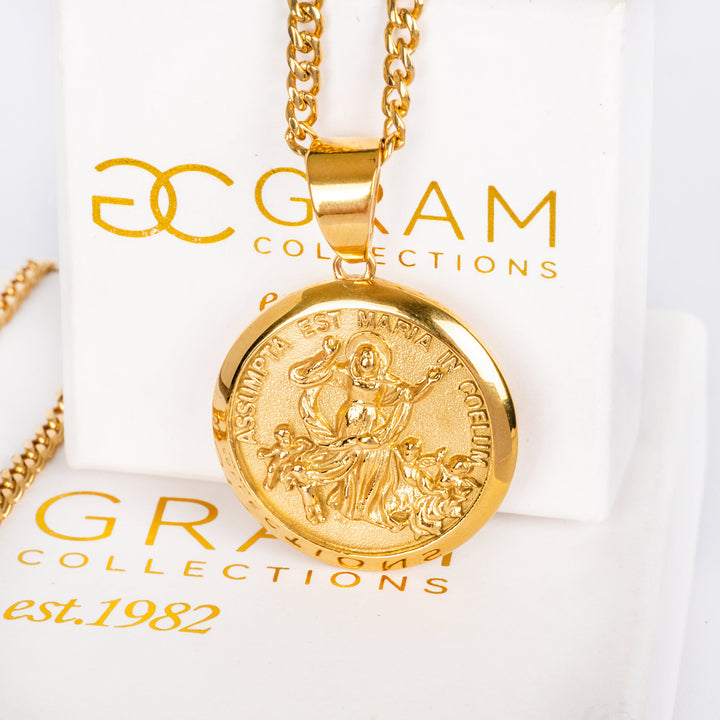 Santa Marija Necklace standing in the center of the image in front of its box that is visible in the background. 