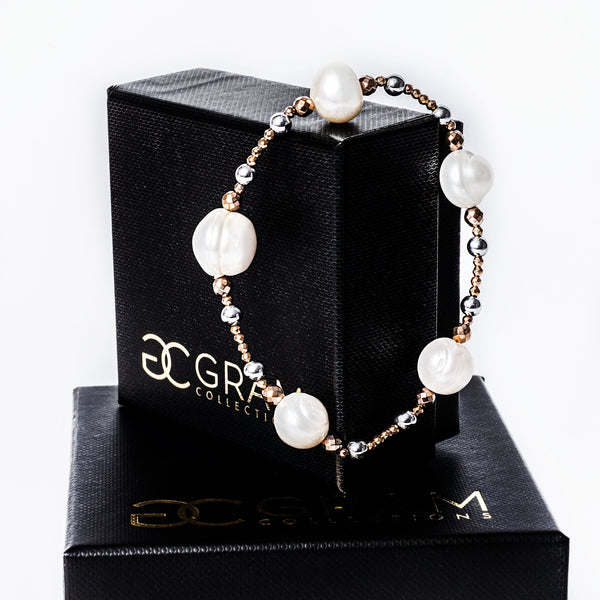 A gram collection Sky bracelet standing attached on its box, surrounded by a white background. 