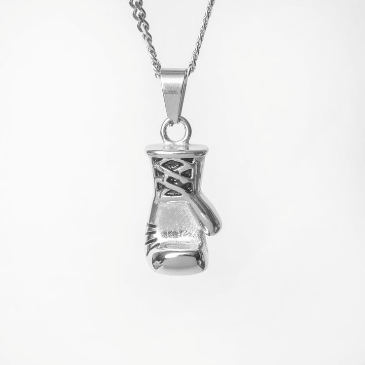 A close up view of The Boxer Necklace silver color standing in the center of the image against a white background. 
