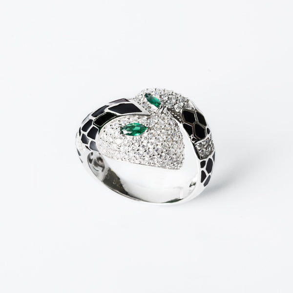 A silver Velma Ring with a heart-shaped inset featuring a green cubic zirconia gemstone, surrounded by a layer of silver and possibly gold accents.