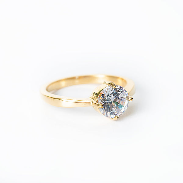 Gold Abigail ring featuring a single large round clear gemstone in a prong setting.