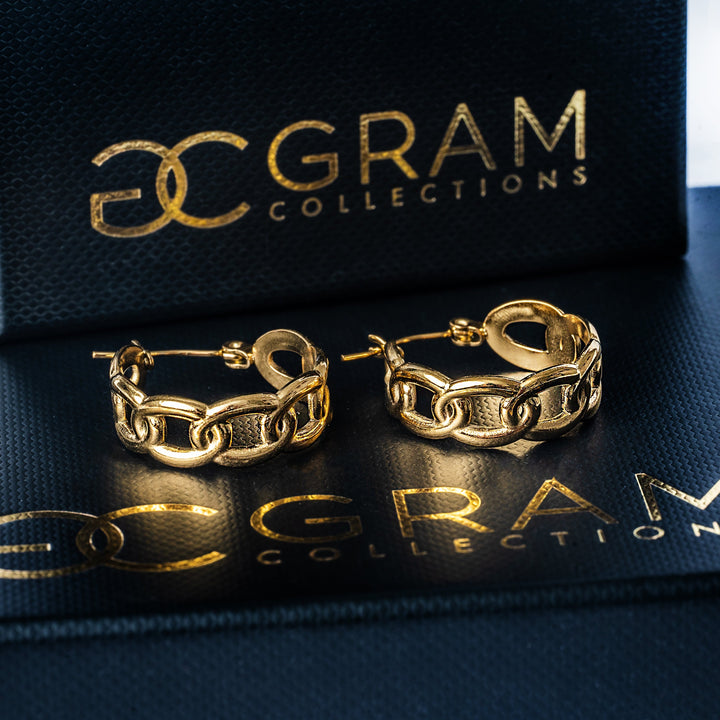 A close up view of Alexandra Gold Earrings standing in the center of the image against a white background. 