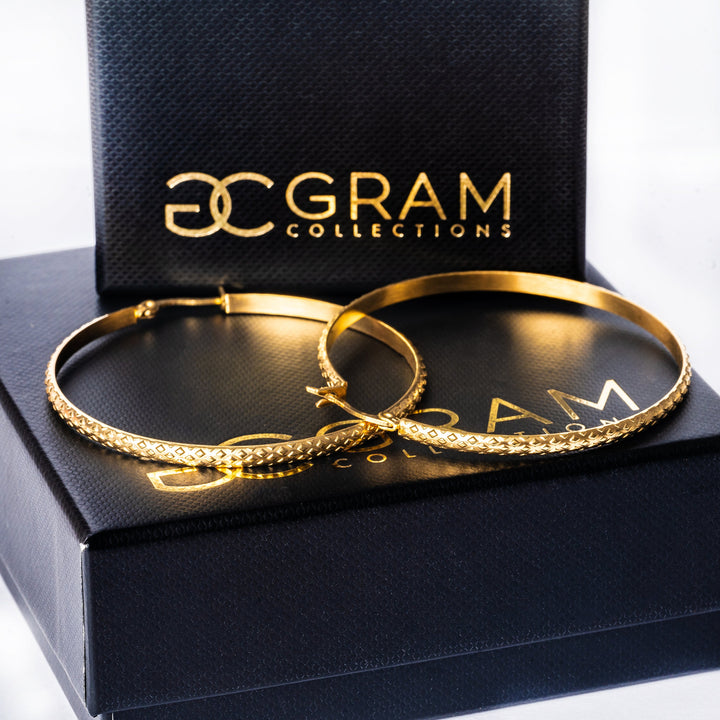 A gold earrings standing in the center of the image. 