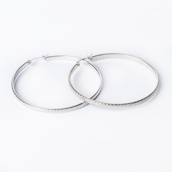 A pair of silver-colored stainless steel hoop earrings with a textured surface, displayed against a white background.