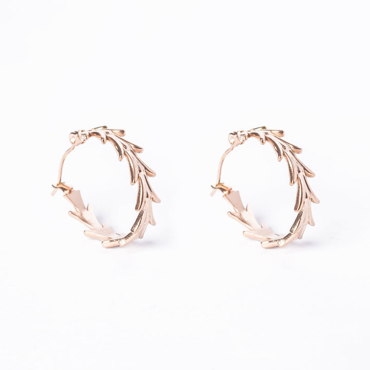 A pair of rose gold colored stainless steel Antonella hoop earrings with leaf patterns, displayed against a white background.