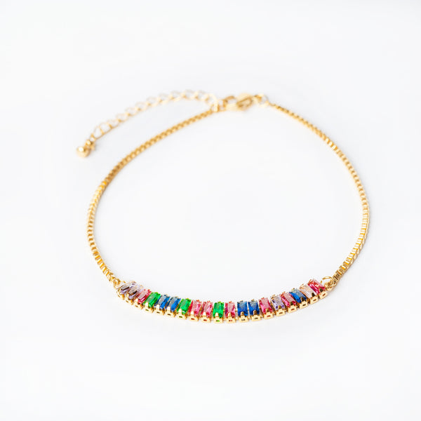 A gold-plated Ariana bracelet with multicolored beads on a white background.