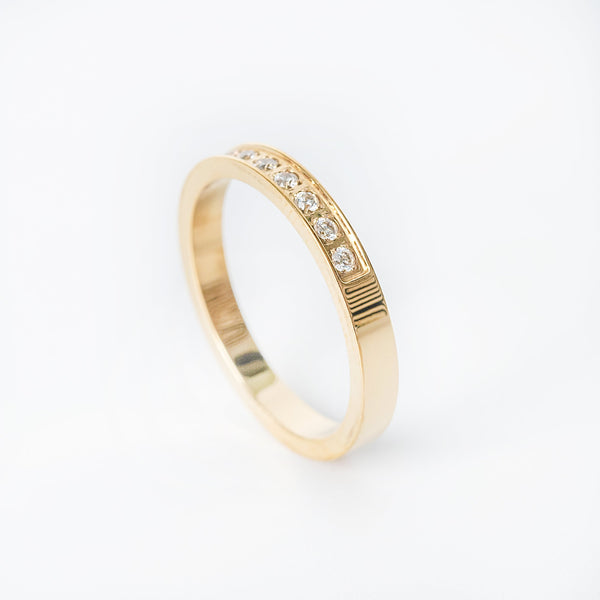 Gold Ava ring featuring a row of small clear gemstones set into the band.