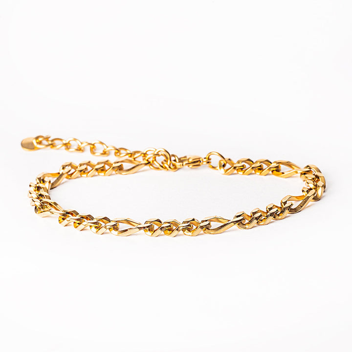 A bari gold bracelet placed in the center of the image against a white background 