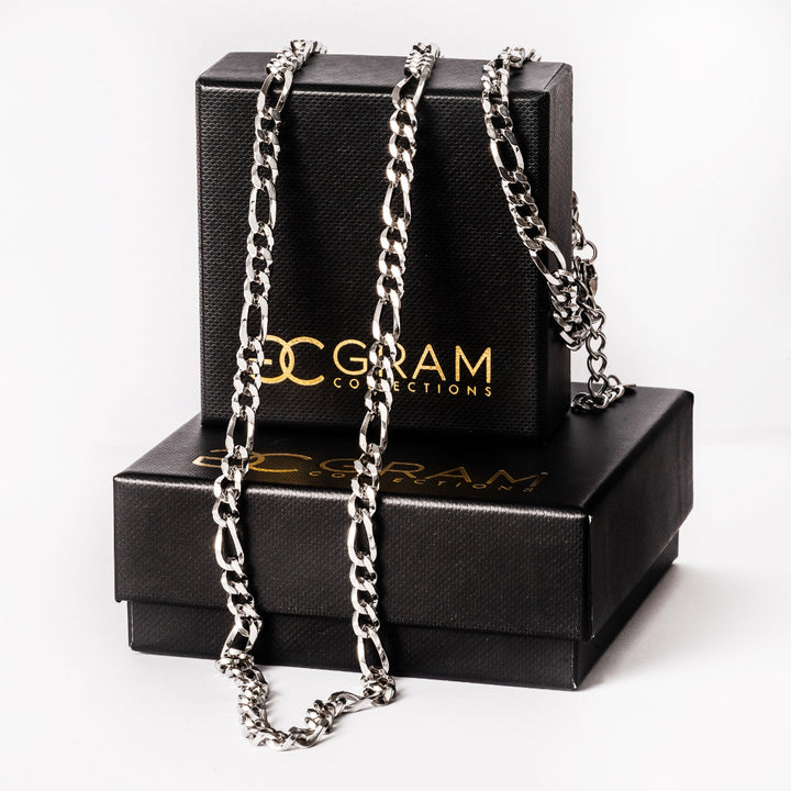 A close up view of bari silver necklace placed in the center of the image, on top of its box. 