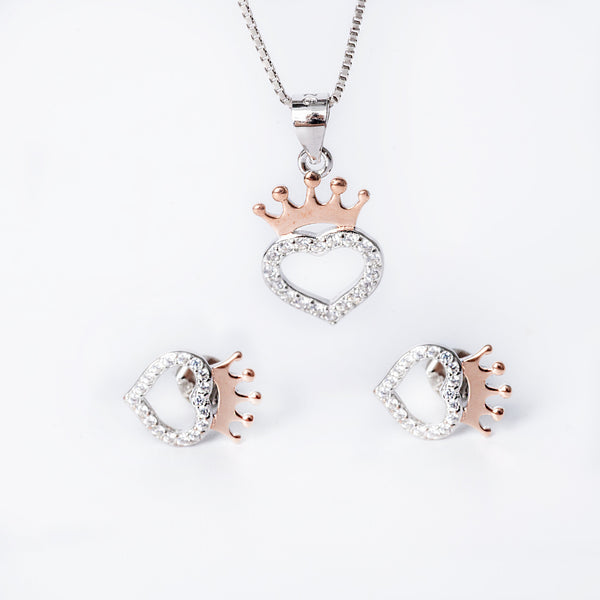 A sterling silver jewelry Bonnie set including a pendant with a crown design, a chain, and a pair of earrings, all adorned with cubic zirconia.