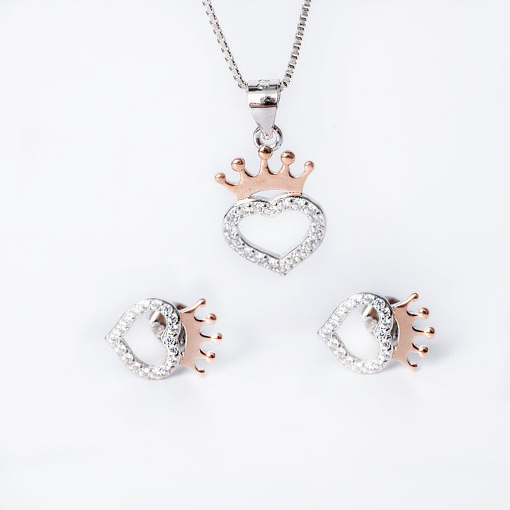 A sterling silver jewelry Bonnie set including a pendant with a crown design, a chain, and a pair of earrings, all adorned with cubic zirconia.