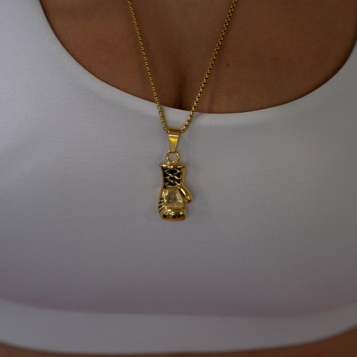 The female model wearing gold boxer necklace, combined with her white t-shirt. 
