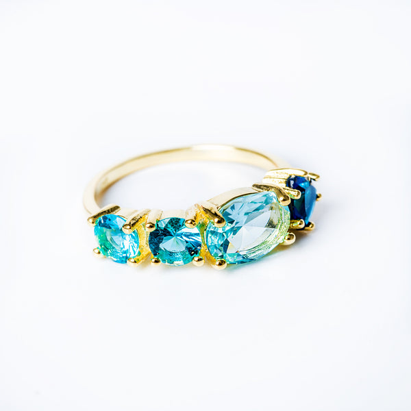 A sterling silver and yellow gold ring with multiple colored cubic zirconia stones set around its circumference.