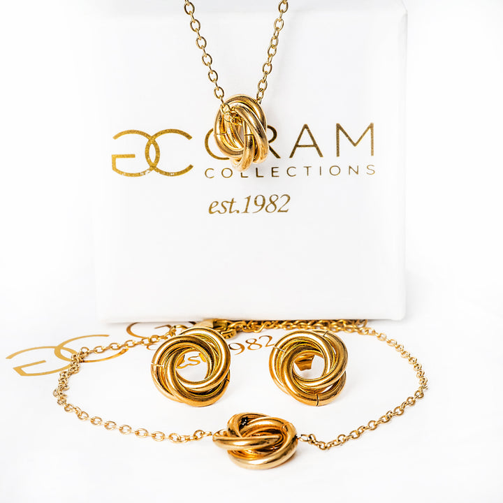 A carmenn gold earrings standing in front of its uniquely designed box. 