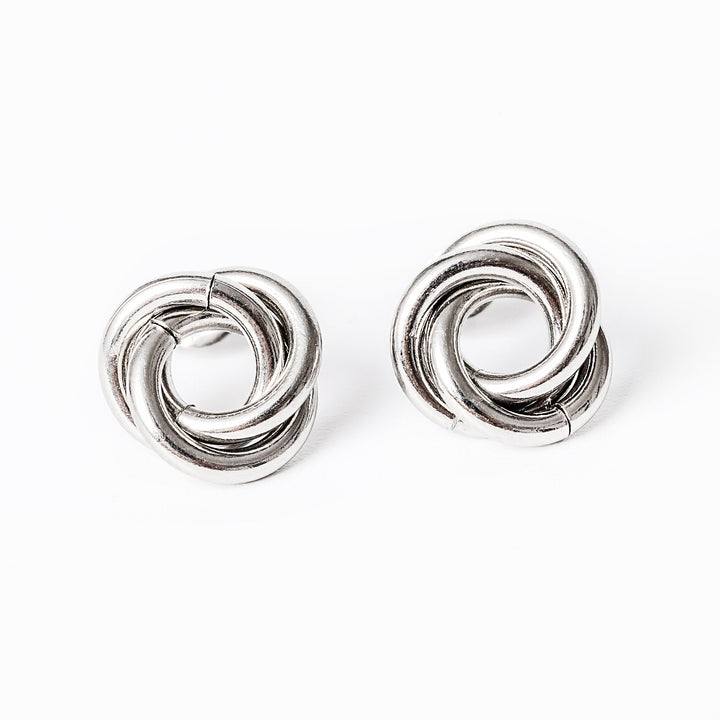 A carment silver earrings standing in the center of the image against a white background. 
