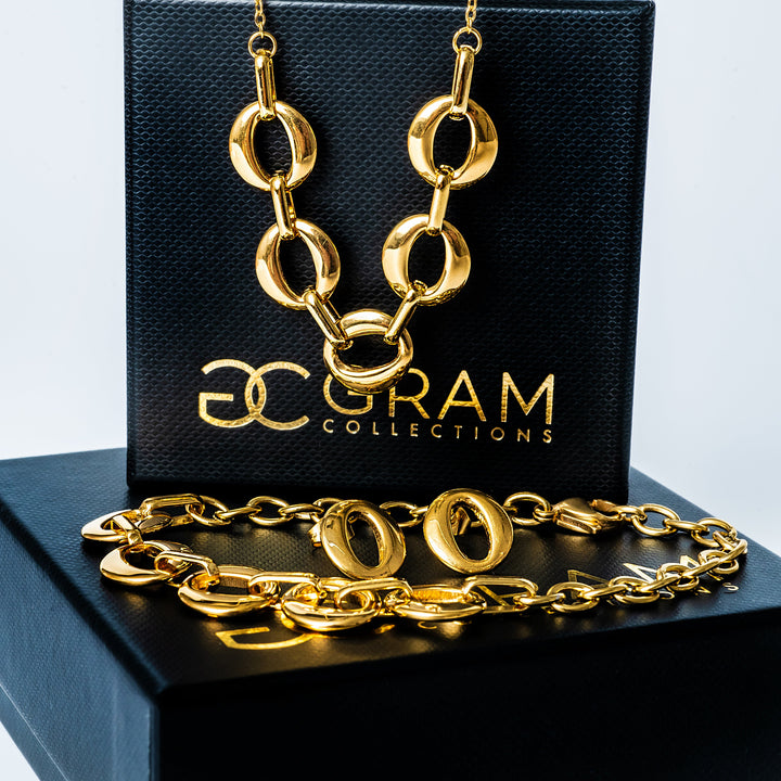 A Chantelle Gold Necklace standing in the center of the image against a white background placed on its box.