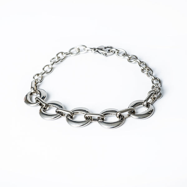 A silver stainless steel bracelet with a gold plated finish, featuring a jewelry clasp.