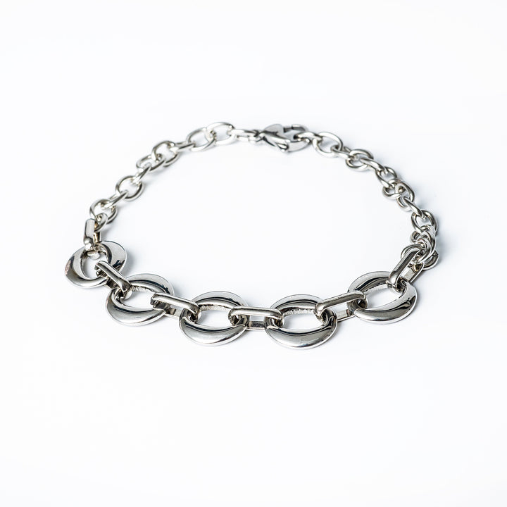A silver stainless steel bracelet with a gold plated finish, featuring a jewelry clasp.