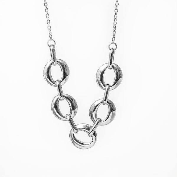 A silver necklace with a series of round charms linked together on a chain.