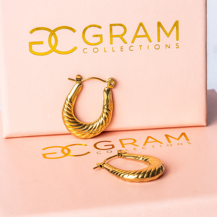 A close up view of Claire Gold Earrings standing in the center of the image against a white background. 