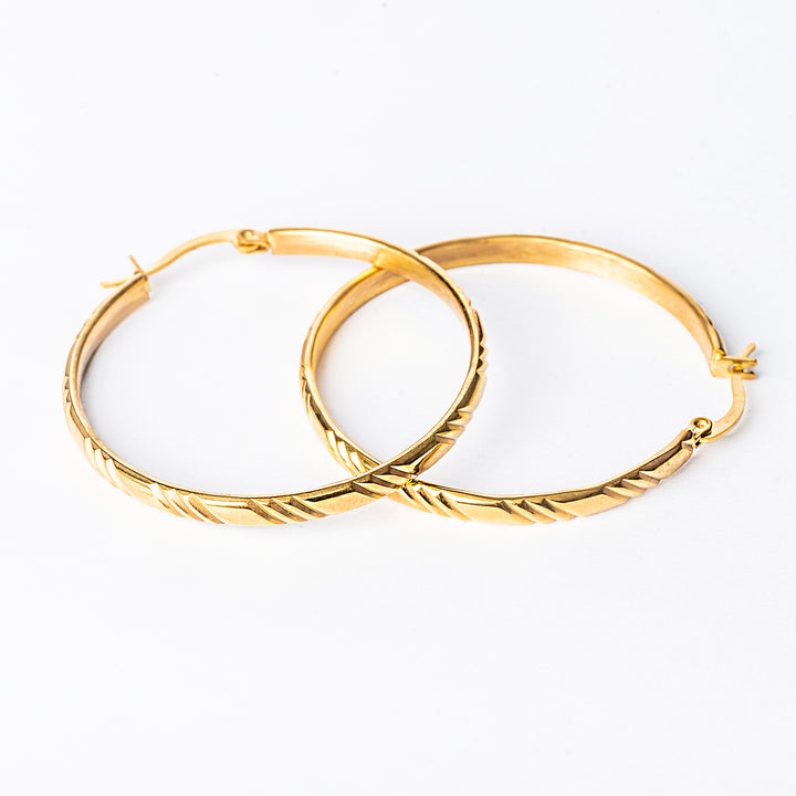 A close up view of maya earrings standing in the center of the image against a white background. 