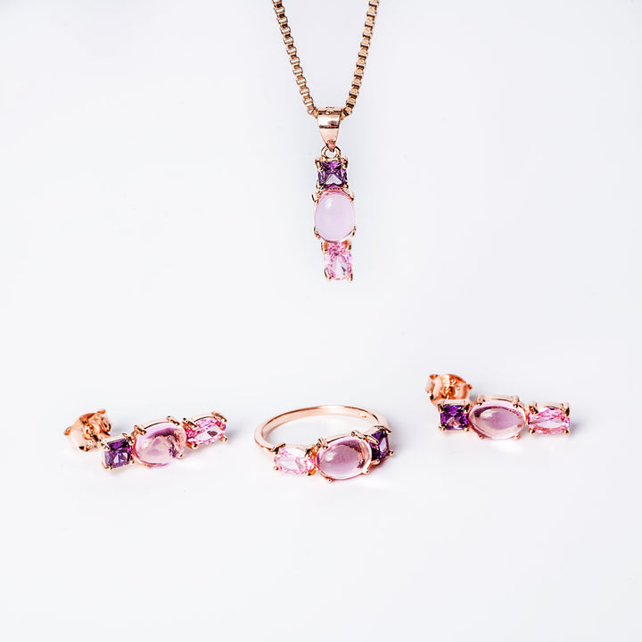 A set of sterling silver jewelry with rose gold accents, featuring colored cubic zirconia gems, including a pendant and earrings with a chain.