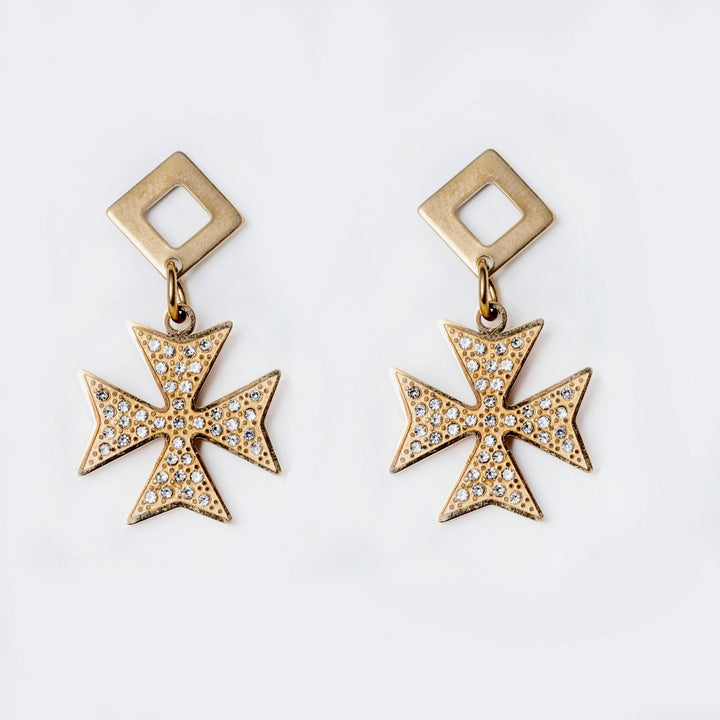 A close up view of Cross of the order Earrings standing in the center of the image against a white background. 