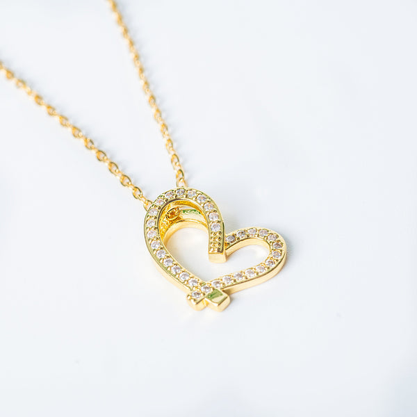 Gold Dakota Necklace featuring a heart-shaped pendant with clear gemstones.