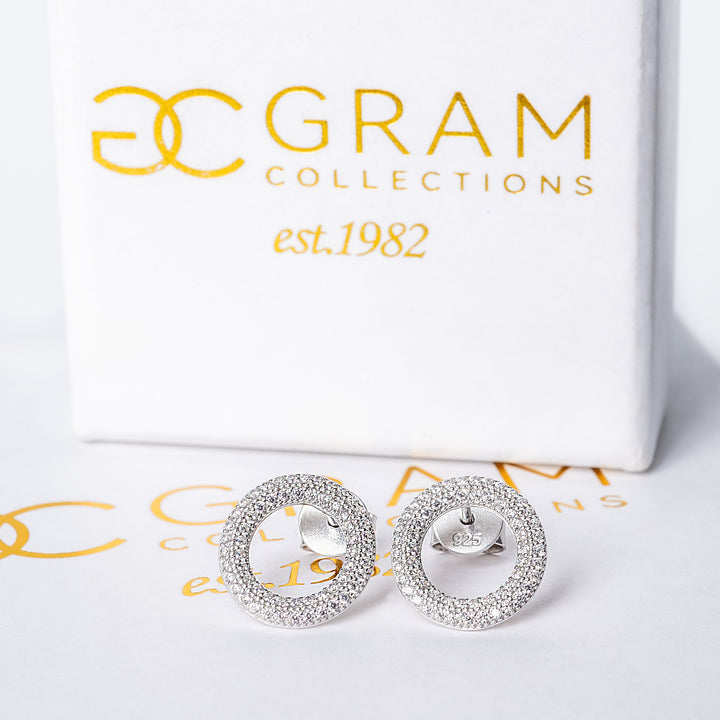 A close up view of Dalphine earrings standing on its box. 