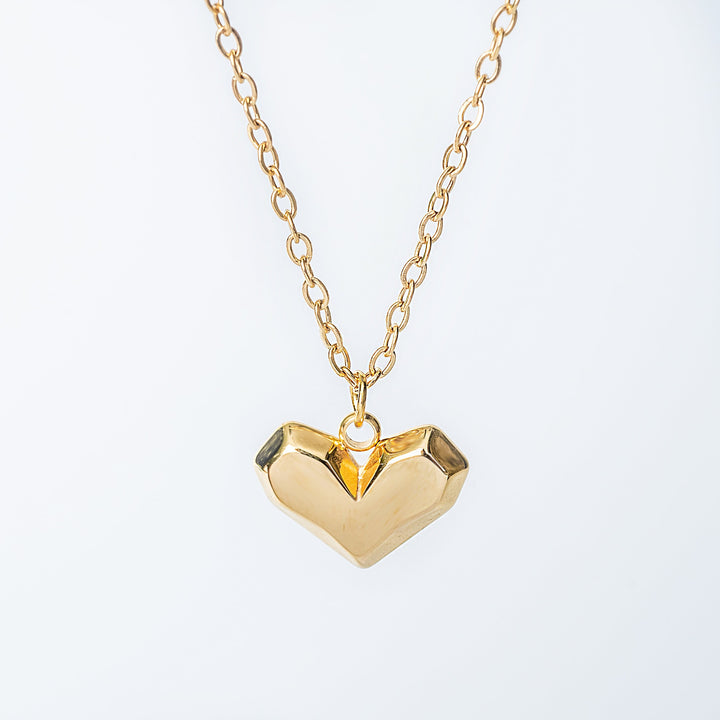 Danita gold necklace with a heart shaped pendant in a close up view