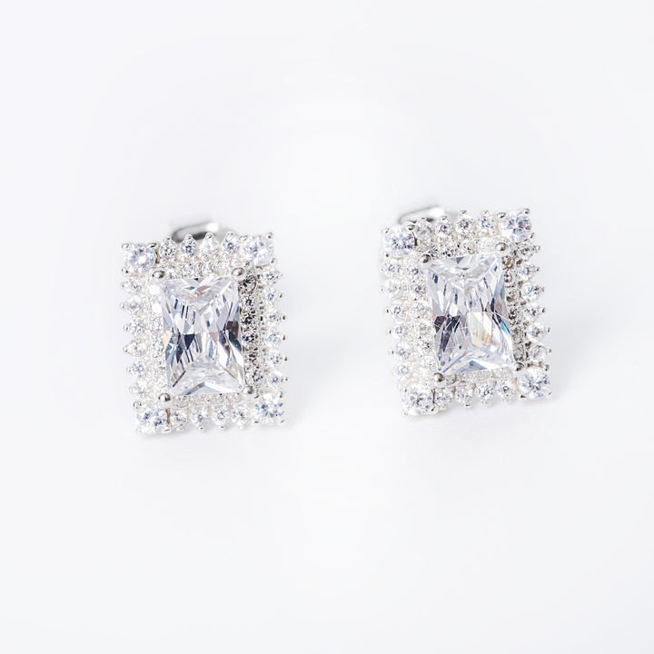 A pair of sterling silver Daphne earrings with a cubic zirconia gemstone in a classic six-prong setting.