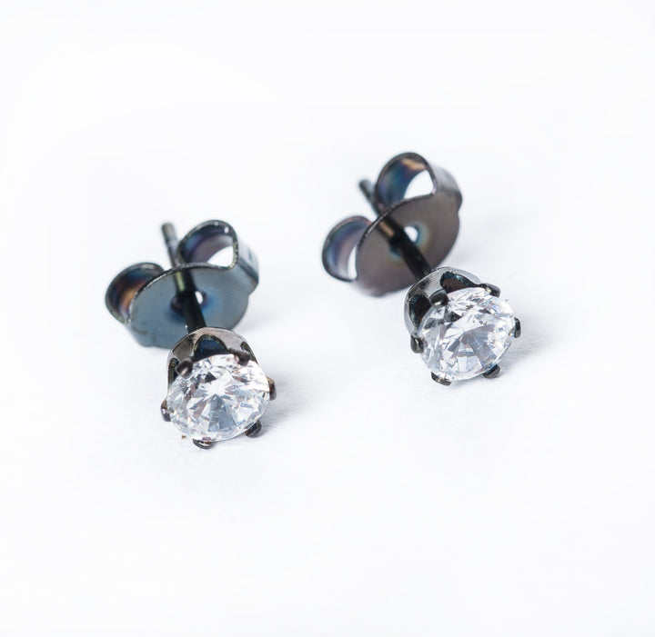 A pair of black stud earrings with AAA cubic zirconia gems, 18ct gold plated on a white background.